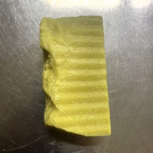 Savon cabosssé posé à plat sur un plan de travail en inox