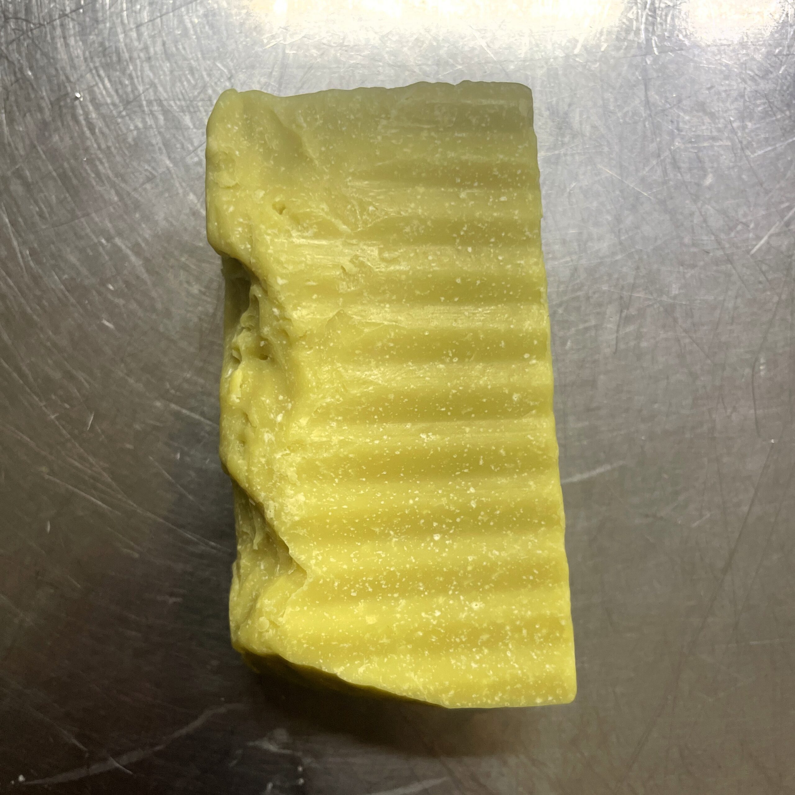 Savon cabosssé posé à plat sur un plan de travail en inox
