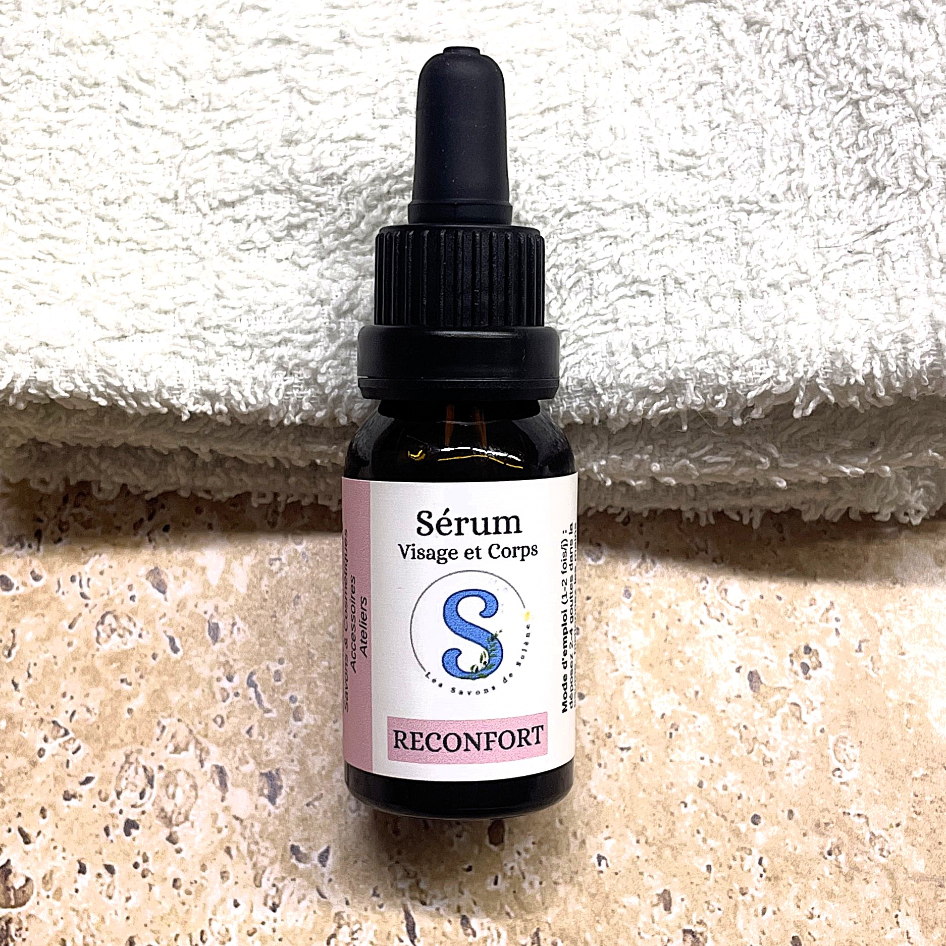 Flacon de sérum blanc er rose avec un bouchon pipette noir.